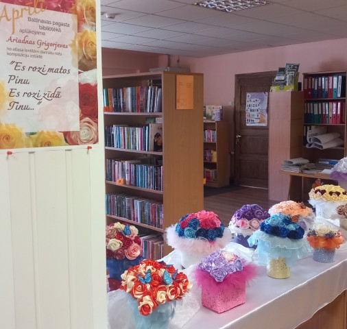 Izstāde no atlasa lentītēm gatavoto rožu kompozīciju.